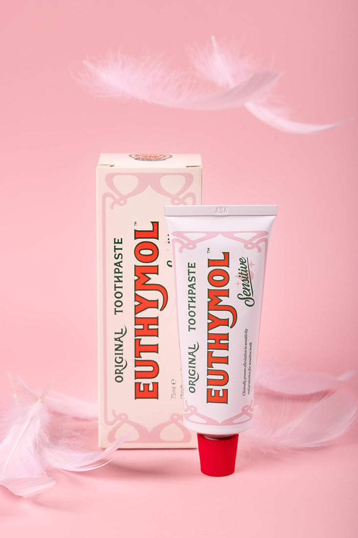 Euthymol Toothpaste Sensitive 75ml in pink background and feathers falling