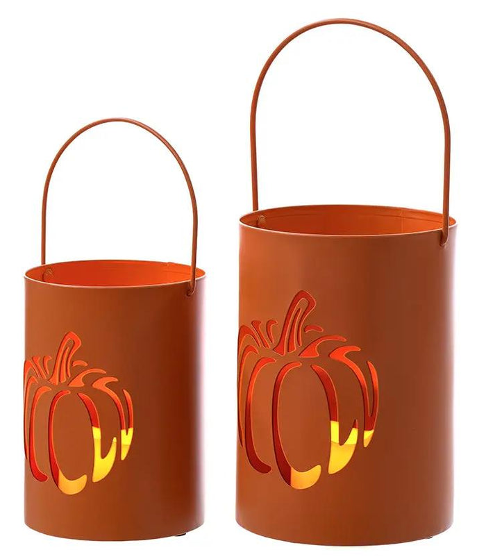 Metal cutout pumpkin can lanterns in two sizes, orange with handles, lit from inside.