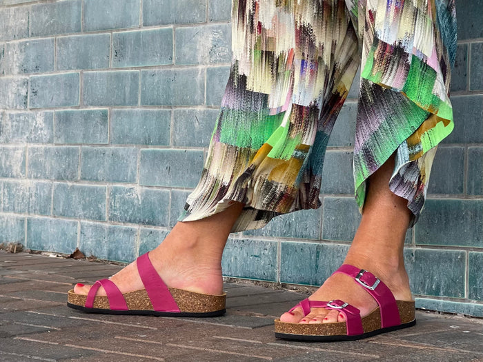 Quality European women's sandals. Made in Spain contoured cork footbed and rubber sole. Comfortable slide style sandal with double buckle detail and toe ring. Birkenstock style sandal in fuchsia.