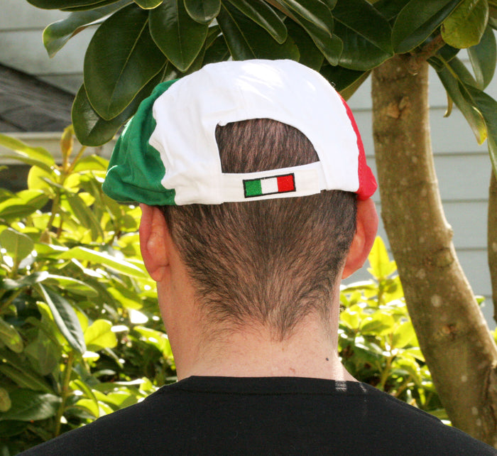 Back view of a Gatsby-style cap featuring three distinct panels in red, white, and green, arranged to reflect the Italian flag. The front displays “ITALIA” embroidered in green thread on the white section, with a red button at the crown. A bold and fashionable tribute to Italian heritage and pride.