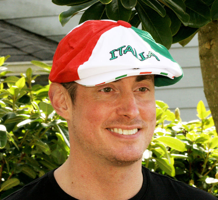 Front view of a Gatsby-style cap featuring three distinct panels in red, white, and green, arranged to reflect the Italian flag. The front displays “ITALIA” embroidered in green thread on the white section, with a red button at the crown. A bold and fashionable tribute to Italian heritage and pride.